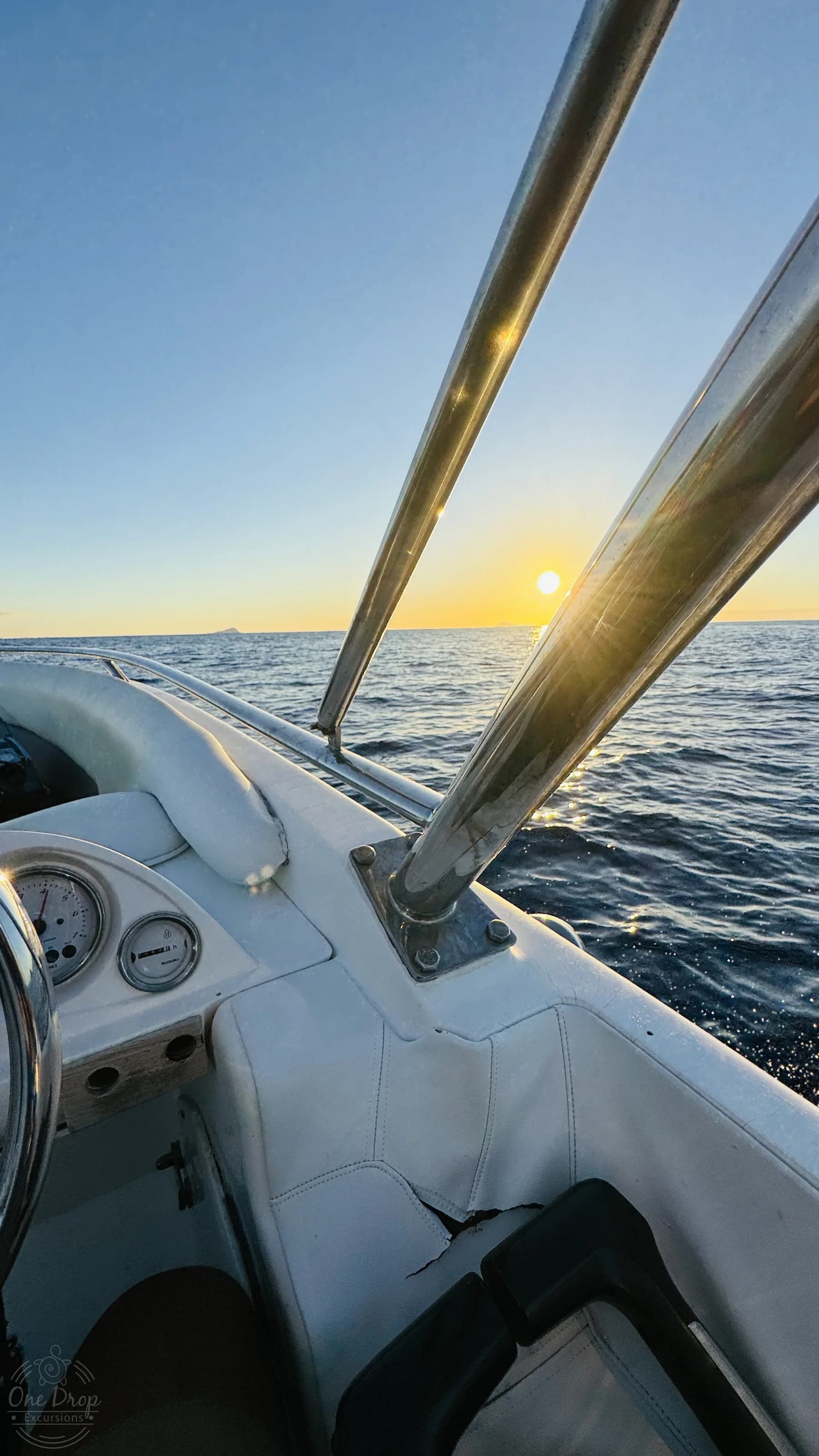 Sunset seen past the rail of a One Drop Excursions boat.